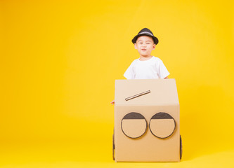 Wall Mural - little children boy smile so happy driving car creative by cardboard