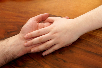    On the male palm lies a female hand. The concept of friendship, love and togetherness.