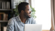 © fizkes - Head shot close up handsome happy young mixed race man distracted from job, looking aside at window. Smiling millennial businessman in eyewear dreaming visualizing future, planning weekend time.
