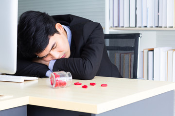 A young Asian businessman begins to have symptoms similar to Covid-19. He is a sleep at working room after taking antipyretics