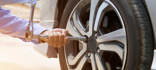 Close up hand of mechanic hands using wrench to changing a car tyre. concepts of car insurance support, repair and services.