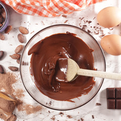 Wall Mural - melted chocolate in bowl with wooden spoon and ingredient