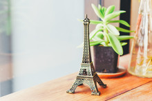 Close-up Of Eiffel Tower Figurine Against Plant On Table