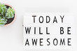 'Today will be awesome' words on a lightbox over white background, overhead view.