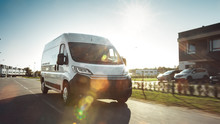 New Delivery Van / Truck Driving Through The Beautiful Suburban Town Area. Postal Delivery Service. Front View Shot