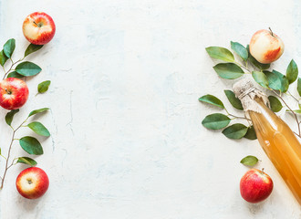 Bottle with homemade apple cider vinegar with apples and green leaves on white background. Frame. Apple season. Healthy fermented food concept