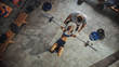 © Gorodenkoff - Top View of Professional Female Bodybuilder Doing Bench Press Workout with a Barbell in the Hardcore Gym, Trainer / Partner Assists with Equipment and Trauma Prevention. Couple Doing Barbell Exercise