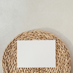Wall Mural - Blank paper sheet with mockup copy space, straw stand on concrete background. Flat lay, top view minimal social media template.