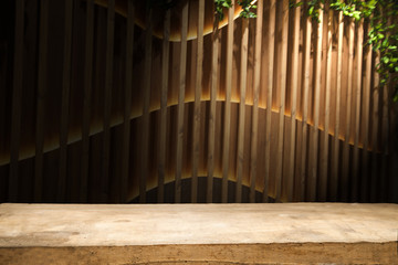 Empty wooden table from above on blur light golden bokeh cafe restaurant, bar on a dark background. with a ray of light on the table.