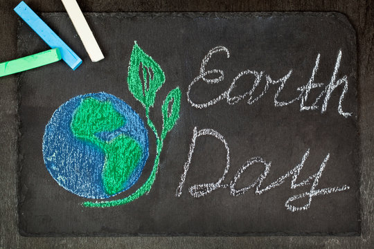 April 22, Chalk drawing planet Earth on a black background -Earth Day.