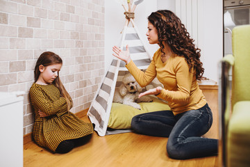 Young mother arguing with her little daughter.