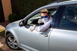 © Aliaksandra - Coronavirus pandemic. Quarantine. Young attractive driver in a medical mask on his face driving a silver car