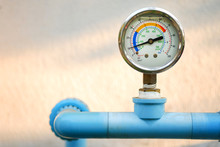 Water Pressure Gauge On Blue Plumbing Pipe With Natural Blur Background, Free Copy Space.