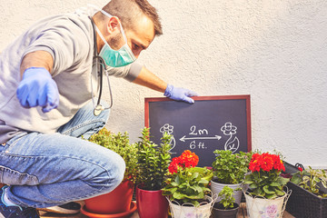 Young professional gardener take care of his plant wearing mask and gloves. Gardening concept. Epidemic concept.