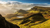 Fototapeta Las - Scenic view of Quiraing mountains in Isle of Skye, Scottish highlands, United Kingdom. Sunrise time with colourful an rayini clouds in background.