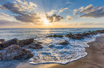 Sunset over the rocky shore of the Gulf of Mexico at Caspersen Beach in Venice Florida