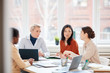 © Seventyfour - Portrait of diverse female business team discussing project while sitting at table during meeting in conference room against window, copy space