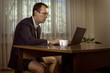 © alexey_arz - Young man in a suit with a tie and male underpants works at the computer at home. Toned