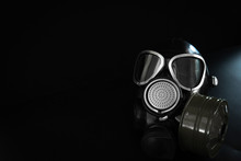 Military Gas Mask With A Filter Box On A Black Background. Personal Respiratory Protection From Dust, Toxic Substances And Viruses. Place For Text.