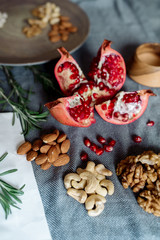 Wall Mural - Pomegranate fruit, walnuts, cashew nuts on the table - healthy food products