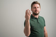 © Cipri Suciu  - Portrait of serious stylish attractive man with thick beard, dressed in casual green t shirt showing number four