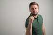© Cipri Suciu  - Portrait of serious stylish attractive man with thick beard, dressed in casual green t shirt showing fist like being mad