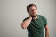 © Cipri Suciu  - Portrait of serious stylish attractive man with thick beard, dressed in casual green t shirt gesturing neck ache