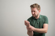 © Cipri Suciu  - Portrait of serious stylish attractive man with thick beard, dressed in casual green t shirt gesturing joint pain