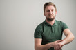 © Cipri Suciu  - Portrait of serious stylish attractive man with thick beard, dressed in casual green t shirt showing late gesture