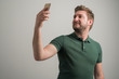 © Cipri Suciu  - Portrait of serious stylish attractive man with thick beard, dressed in casual green t shirt taking selfie photo