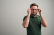 © Cipri Suciu  - Portrait of serious stylish attractive man with thick beard, dressed in casual green t shirt puts his glasses on his eyes