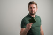 © Cipri Suciu  - Portrait of serious stylish attractive man with thick beard, dressed in casual green t shirt showing wallet