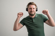© Cipri Suciu  - Portrait of serious stylish attractive man with thick beard, dressed in casual green t shirt listening and danceing on music
