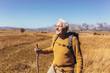 © Mediteraneo - Senior man on hike through beautiful countryside in autumn.
