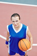 © DragonImages - Serious young sportswoman with basketball ball looking up in camera