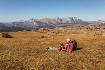 Wall Mural - Boy camping with grandfather in autumn.