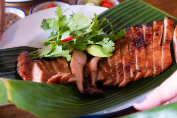 Wall Mural - Close up juicy yummy fried sliced pork on green banana leaf , popular traditional thai food.