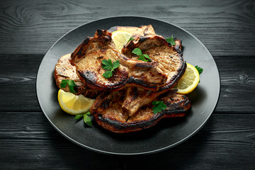 Wall Mural - Homemade Grilled Pork loin chops in lemon sauce with herbs on rustic wooden table