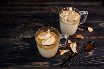 Wall Mural - Delicious and fragrant dalgona coffee in glass cups, cinnamon sticks, dried mushrooms, a spoon of instant coffee, sugar.