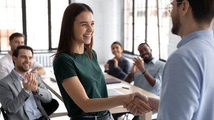 businessman shake hand of excited caucasian female employee greeting with achievement or success at 