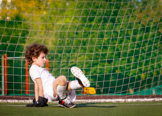 Wall Mural - Summer soccer tournament for young kids. football club. emotions and joy of the game. Young goalie. Kids - soccer champion. Boy goalkeeper in football sportswear on stadium with ball. Sport concept.