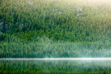 Canvas Print - Green lake between mountains in cloudy day