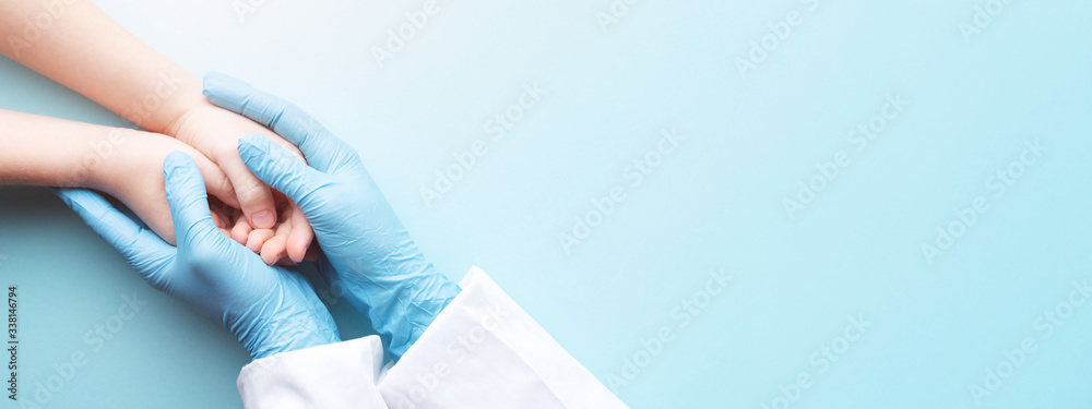 Doctor's hands in gloves holding child's hands. Medical banner with copy space on blue background. Care concept. - obrazy, fototapety, plakaty 