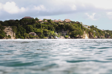 Wall Mural - view of houses on rocky coastline by sea