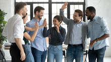 Overjoyed Multiracial Colleagues Have Fun Celebrate Shared Business Victory Or Win At Workplace, Happy Diverse Multiethnic Businesspeople Engaged In Funny Teambuilding Activity In Office Together