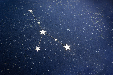zodiac sign cancer on the starry sky close up. star confetti and shiny black cardboard applique. the