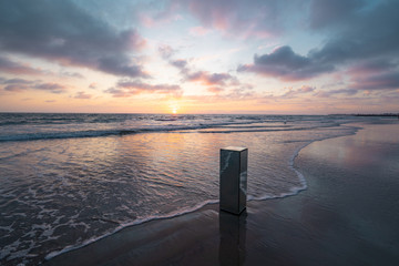 Wall Mural - view of mirrored pillar on beach during sunset