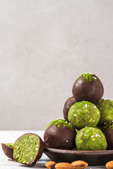 Wall Mural - Green matcha energy balls or energy bites with energy balls in chocolate glaze. Healthy vegan diet snacks