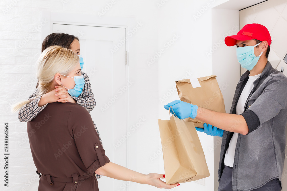 Young woman wearing medical mask receiving orderd food from the ...