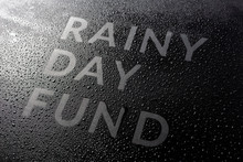 The Dry Words Rainy Day Fund Covered From Water Drops On Black Surface, Unusual Implementation Concept